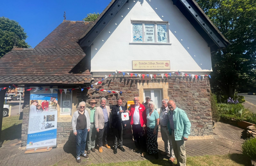 Jack Lopresti MP standing in front of Frenchay Village Museum presenting a defibrillator.