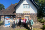 Jack Lopresti MP standing in front of Frenchay Village Museum presenting a defibrillator.