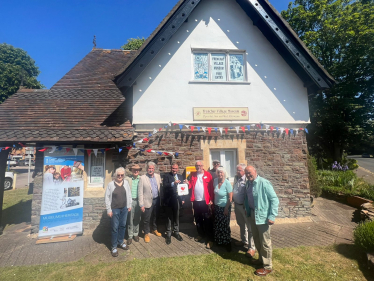 Jack Lopresti MP standing in front of Frenchay Village Museum presenting a defibrillator.